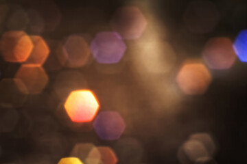 Orange lights in blur with hexagonal bokeh effect on dark background for overlay.