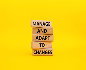 Manage and Adapt to Changes symbol. Wooden blocks with words Manage and Adapt to Changes. Beautiful yellow background. Business and Manage and Adapt to Changes concept. Copy space.