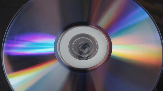 Scratched many times used cd spinning slowly, close up compact disc