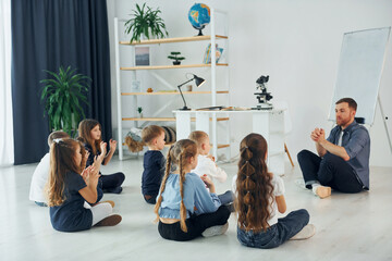 Fototapeta premium Man teaches gesture language. Group of children students in class at school with teacher