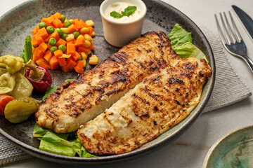 grilled fish with salad and raita served in a dish isolated on grey background side view of fastfood