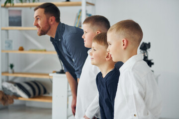 Man standing with boys in the room and looking to the side