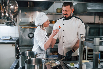 Woman and man woking together. Professional chef preparing food in the kitchen