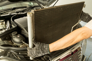 Auto mechanic remove air conditioning condenser to maintenance, Car maintenance service. - obrazy, fototapety, plakaty
