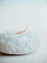 Bird feather white stone white blank background soft calm focus. background. Spa background with a space for a text. Spa wellnes greeting card. aromatherapy theme , handmade cosmetic