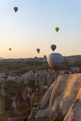 Landscape of the Valley of Love in Cappadocia, at dawn, with hot air balloons flying.