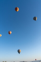 Landscape of the Valley of Love in Cappadocia, at dawn, with hot air balloons flying.