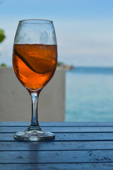 ORANGE COCKTAIL IN FRONT OF THE BLUE SEA AND SKY