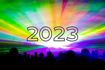 Happy new year 2023 colorful laser show party people crowd. Luxury entertainment with audience silhouettes turn of the year celebration. Premium nightlife event at holidays season party time