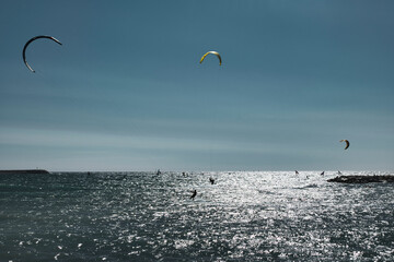 Multiple kite surfers and wing foilers at the ocean. Kite surfing in the afternoon sun. Ocean, adventure water sports in Marseille, France.  - Powered by Adobe