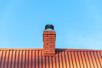 brick chimney made of clinker bricks with a chimney cowl. The roof is covered with corrugated steel...