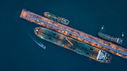 Aerial view tanker ship vessel unloading at port at night, Global business logistic import export...