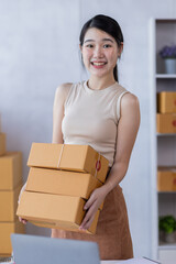 SME entrepreneur Business Young Asian freelance girl works with a laptop and box at home, about eCommerce, business, seller, Asian, employee, entrepreneur, box, merchant, Online SME business ideas,