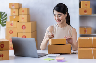 SME entrepreneur Business Young Asian freelance girl works with a laptop and box at home, about eCommerce, business, seller, Asian, employee, entrepreneur, box, merchant, Online SME business ideas,