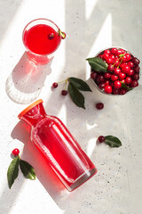Cold cherry juice in a glass and bottle with ripe berries. Top view. The concept of summer refreshing drink morse or kompot. © Лариса Андреева