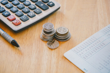 Stack of money coin on office desk with bank book, pen and calculator. Business and financial...