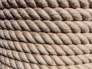 texture, background. a strong, solid rope is wound on a reel. twine for binding made of durable brown material. threads are pulled from the rope