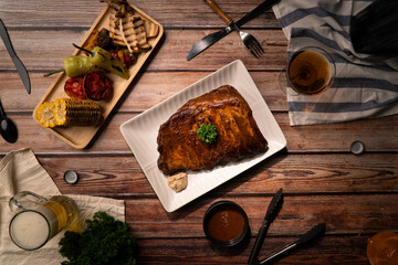 Top view Grilled BBQ Rib serve in white square ceramic plate on wood table with drink and snack appetizer of meal