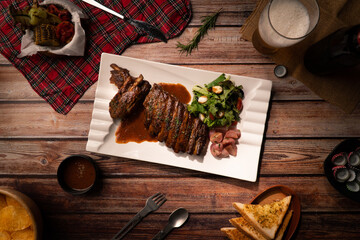 Top view Grilled BBQ Rib serve in white square ceramic plate on wood table with drink and snack appetizer of meal