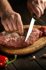 Chef hands cutting raw veal on a cutting board before cooking. Asian food or cuisine