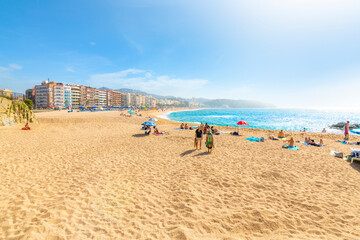 The wide sandy beach at the Costa Brava resort town of Lloret de Mar, Spain, as the fog breaks and...