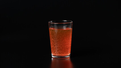 Glass with carbonated orange water on a black background, bubbles, drink, cocktail