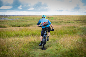 Cyclist wearing blue top and black shorts along the Pennine Bridleway