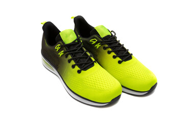 Trendy sports shoes, with a black and yellow color gradient, and white soles, isolated on white background.