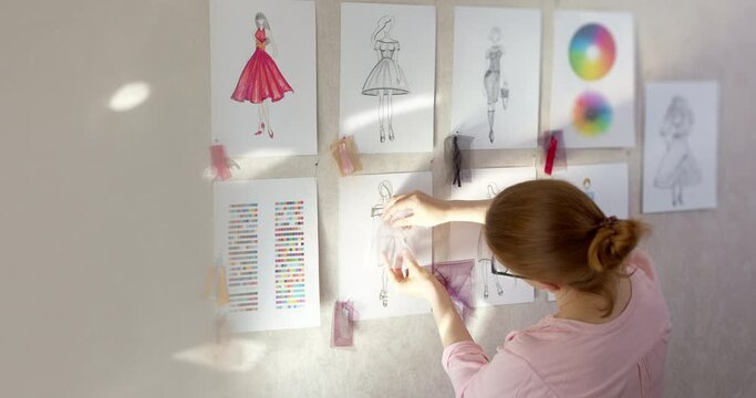 The fashion designer develops sketches of clothing design. The artist creates women's dresses. Tailor working with fabric.