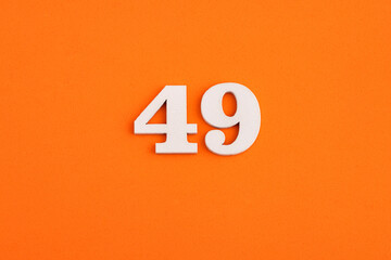 White wooden number 49 on eva rubber orange background