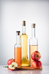 Bottled apple cider vinegar and fresh apples.