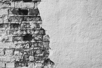 Texture of old brick wall with collapsed plaster. Background of shabby building surface. Destroyed Concrete and Brick wall with fallen plaster. Copy space. Black and white photo. Selective focus.