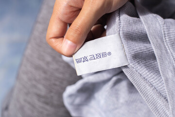 Women reading instructions on clothing labels, laundry care labels, washing instructions, housework