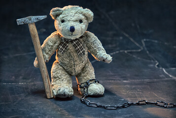 The Teddy bear symbolizing a child. Teddy bear works hard, holds a hammer in its paws. Stop child...