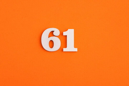 White wooden number 61 on eva rubber orange background