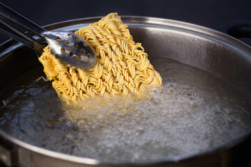 Boil instant noodles in boiling water in a country kitchen.