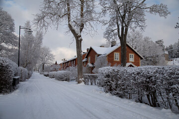 Sweden. Winter snowy village street with red brick houses