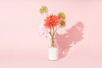 Bouquet of flowers in vase against pink background. Spring, summer minimal idea. Floral home decor.
