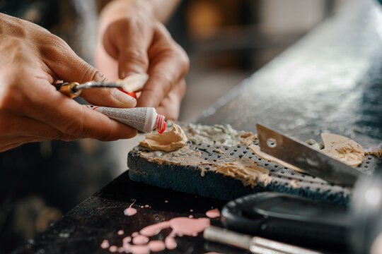 Close-up: artisan sculptor artist man works with paint. Homemade