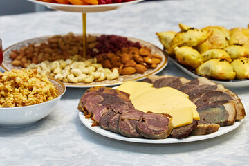 table served with sliced meat with cheese, dried fruits and nuts, and other dishes