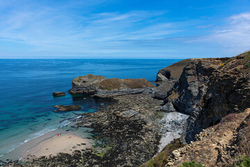 Idyllic landscape of the British Cornwall coast. Blue sky over turquoise sea and rocky beach with cliffs. Paradise on Earth scenery. Perfect holiday destination.