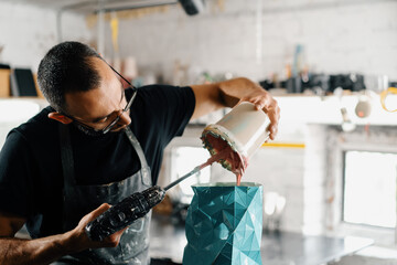 Male artist sculptor artisan creates a vase with his own hands in an art workshop.