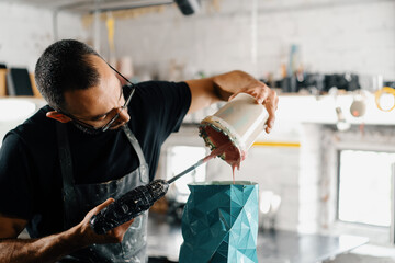 Male artist sculptor artisan creates a vase with his own hands in an art workshop.