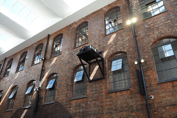 the windows and bricks of an old silk mill factory building. Background for engineering, work,...