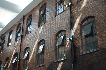 Fototapeta premium the windows and bricks of an old silk mill factory building in England Great Britain. Background for engineering, work, labour, industry architecture.