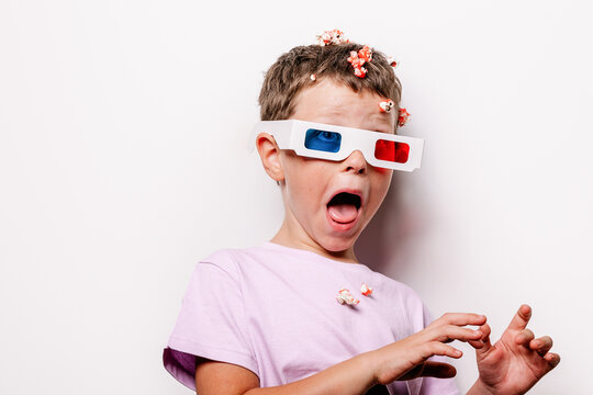 Boy in 3D glasses throwing popcorn