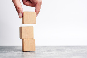 hand holding and stacking wooden block cube step of business growth success. concept of grow...
