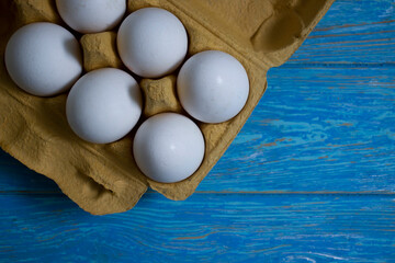 Tray of eggs on wooden background