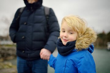 Father and his son walking on cold windy winter day. Single parent.