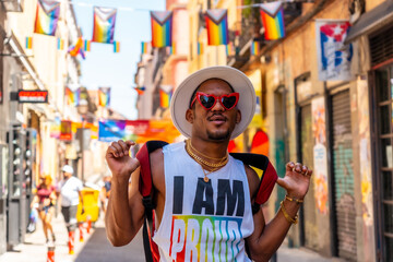 Obraz na płótnie Canvas A gay black man at the pride party visiting the decoration of the city, LGBT flag
